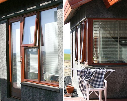 Gluggar og glerjuð hurð úr viði á horni húss.